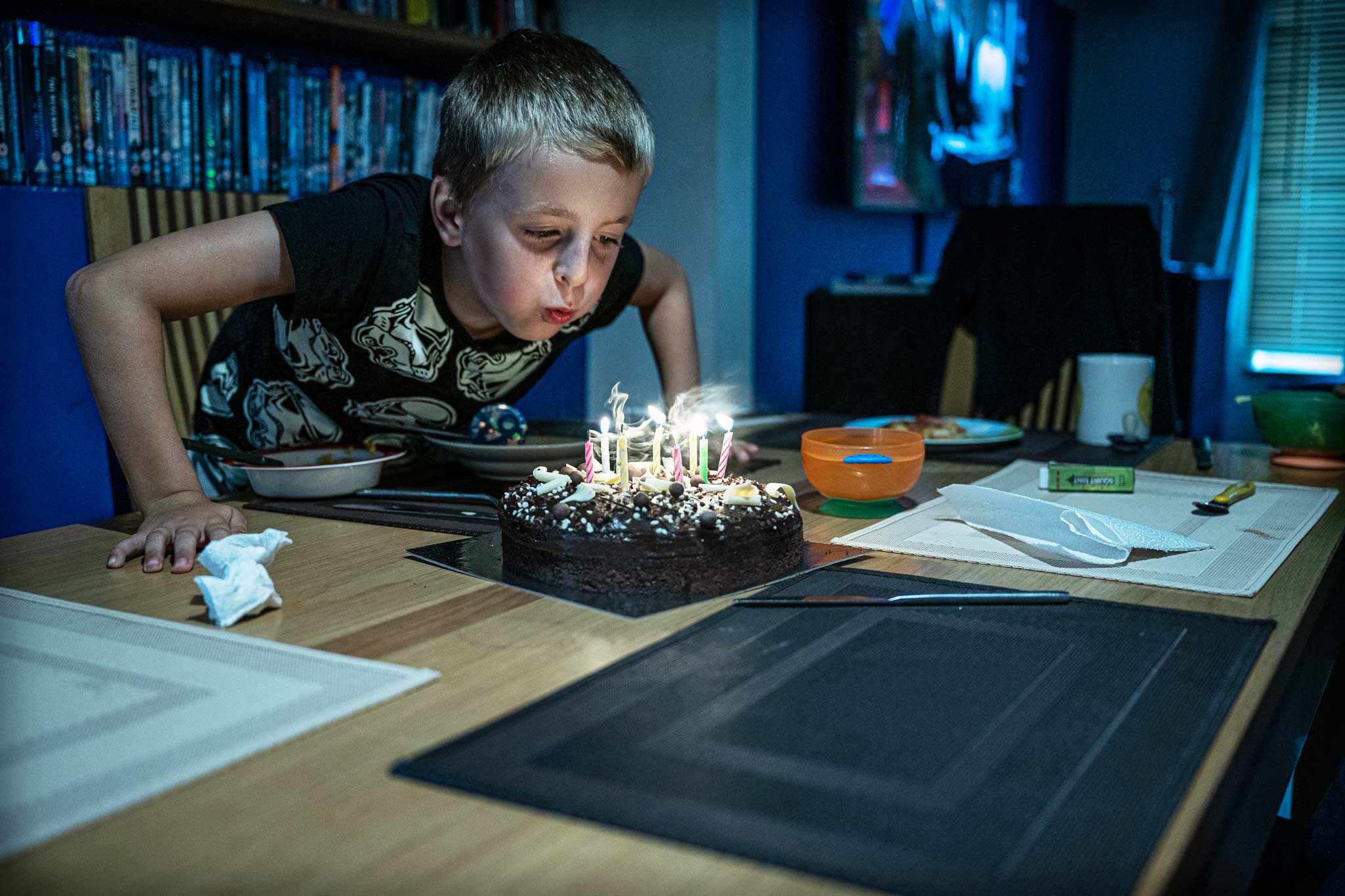 Young Boy Caden blows out candles on cake in Plymouth Childrens Birthday Photography Session