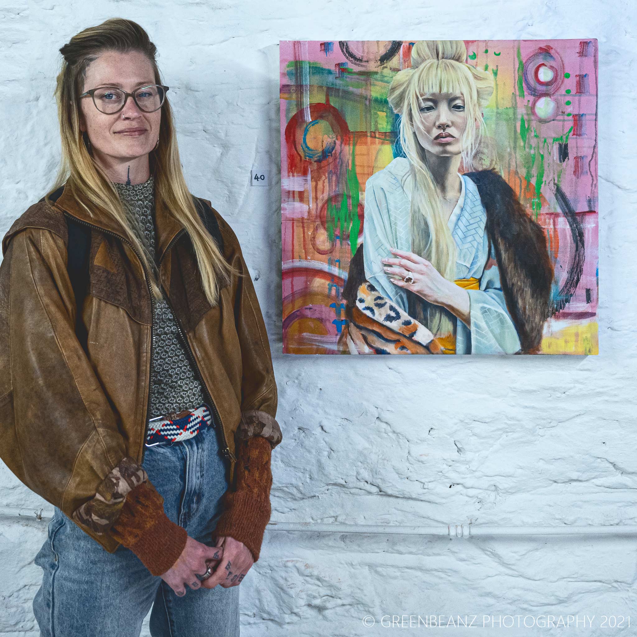 Roisin Cunnigham with one of her exhibited portraits