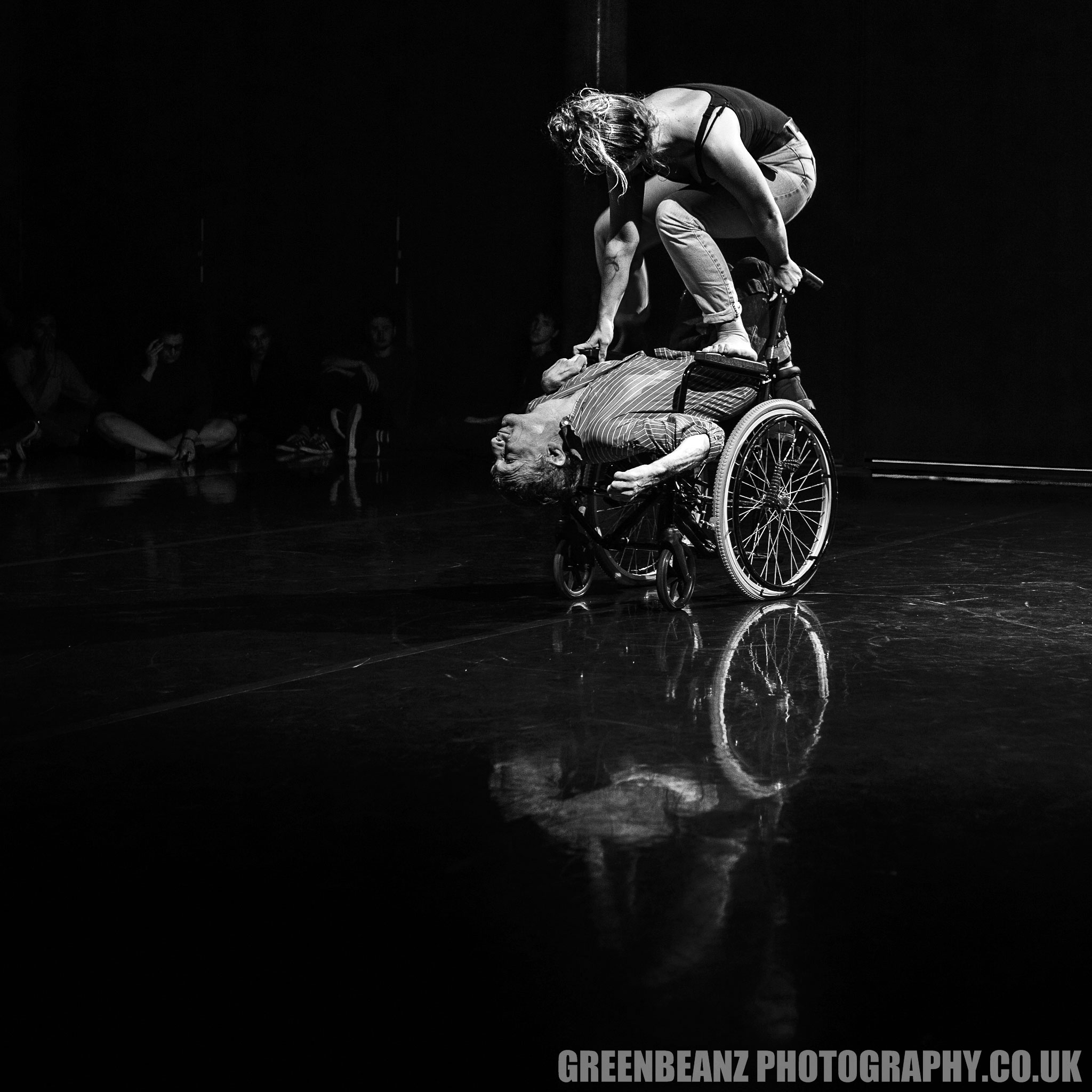 Cloey stnad on Kevin's Wheelchair during dance sequence