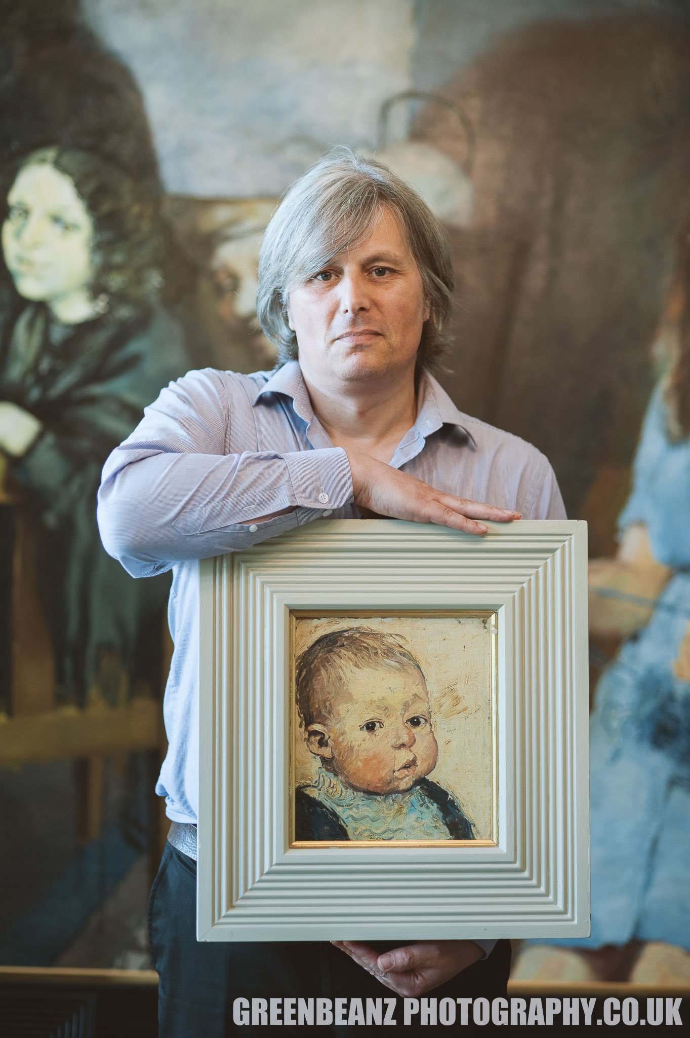 Reuben Lenkiewicz holds a portrait of himself as a baby painted by father Robert