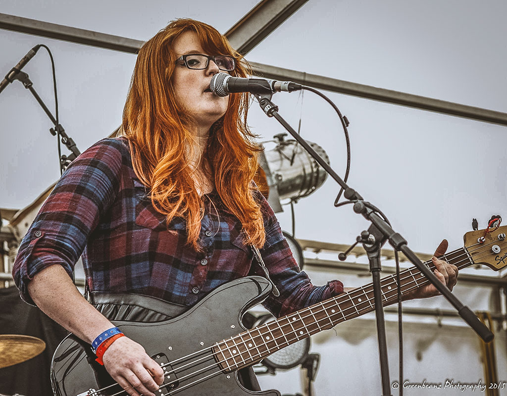 Photograph of bass player Naomi Girdler of the band 'Worried Shoes' playing live at Freedom Fields festival Plymouth